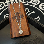 Silver double-chain necklace with heart pendant on wooden display card