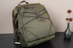 Olive green backpack with front bow-shaped braided design and top handle