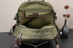 Olive green backpack with front zip pocket, small logo patch, and shoulder straps