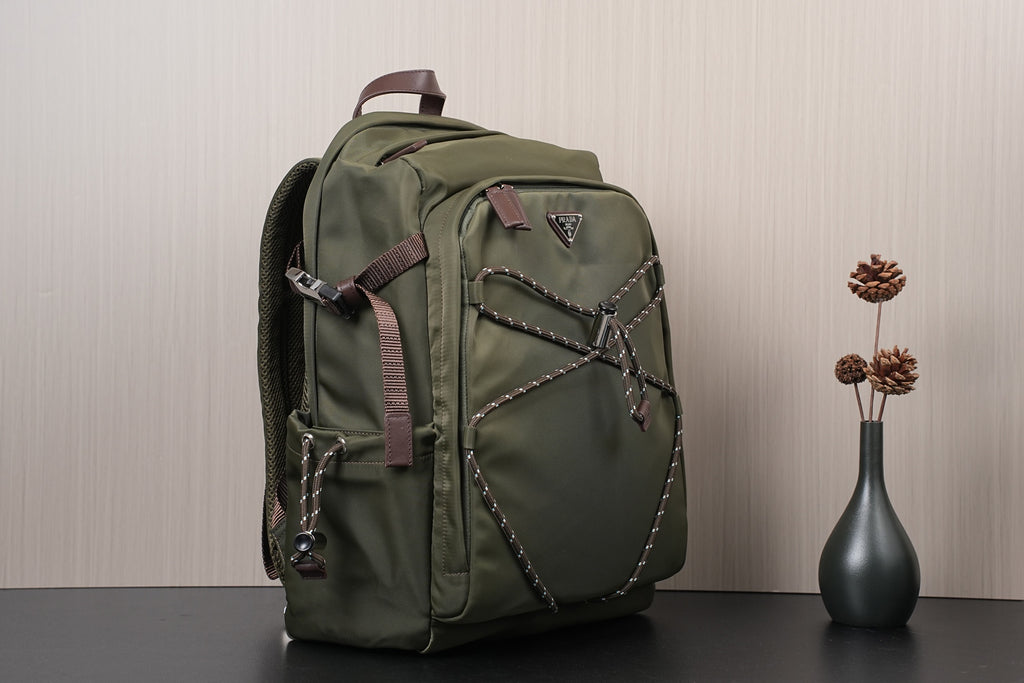 Olive green backpack with side flap, front logo patch, and braided strap details