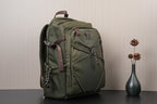 Olive green backpack with side flap, front logo patch, and braided strap details
