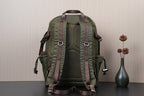 Olive green backpack with textured back panel, brown straps, and side pockets