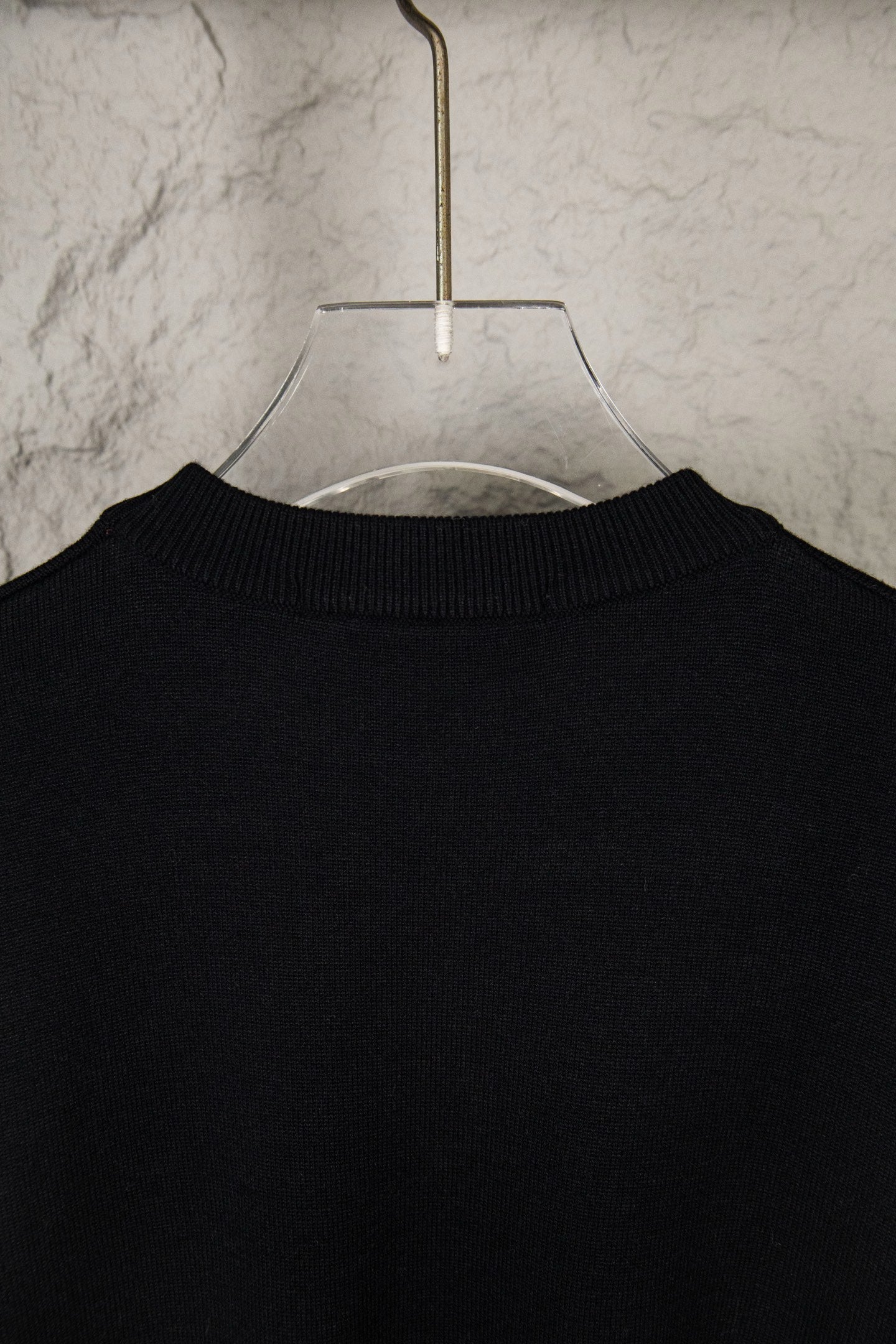 Black knit sweater crewneck collar on hanger
