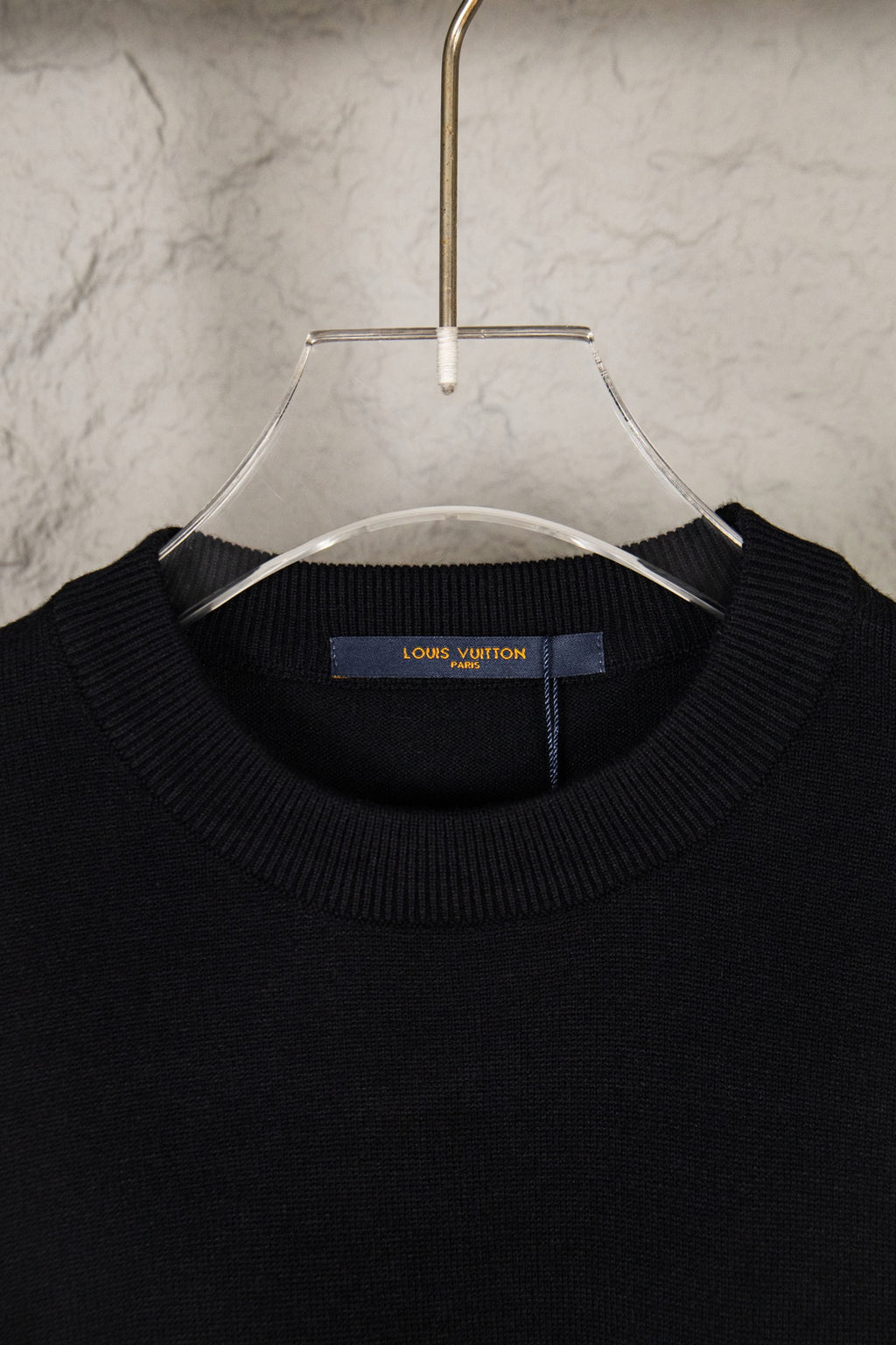 Black knit sweater neckline with Louis Vuitton label