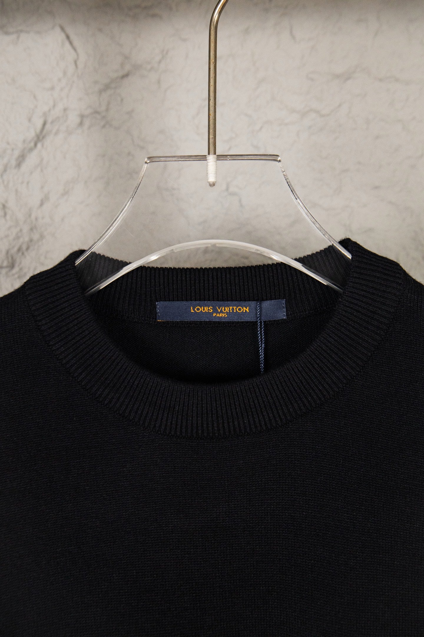 Black knit sweater neckline with Louis Vuitton label