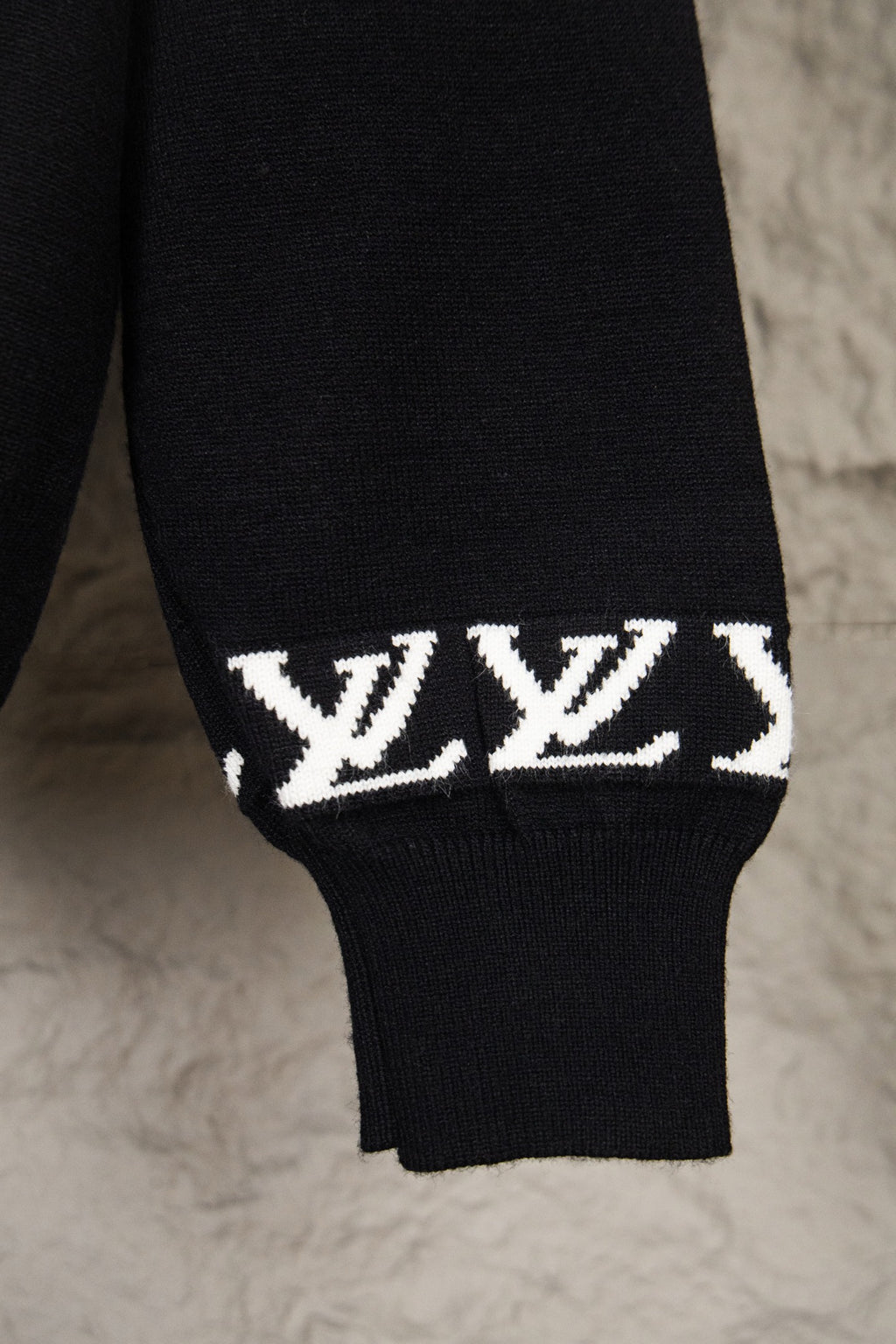 Black knit sweater sleeve cuff with white LV monogram band