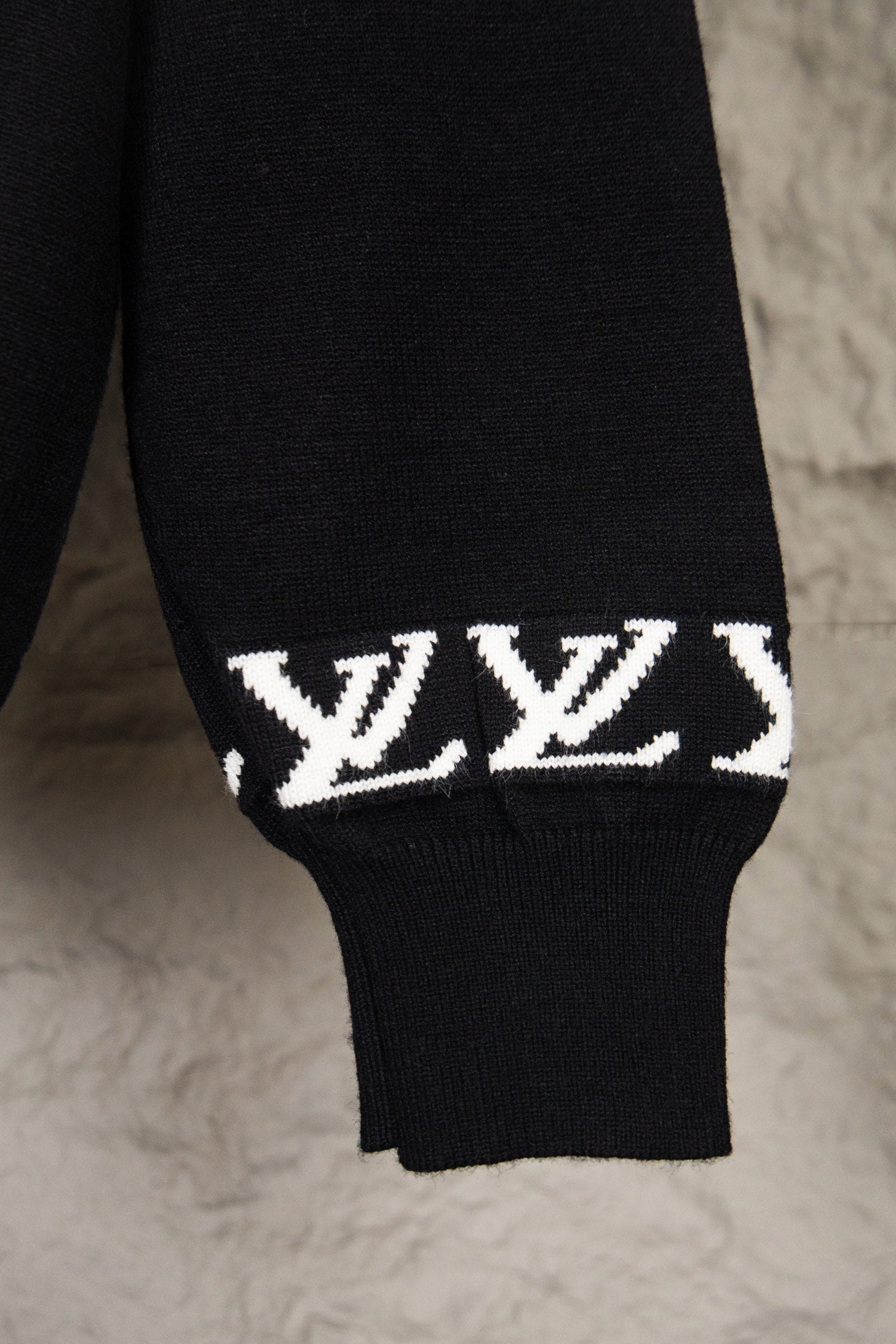 Black knit sweater sleeve cuff with white LV monogram band