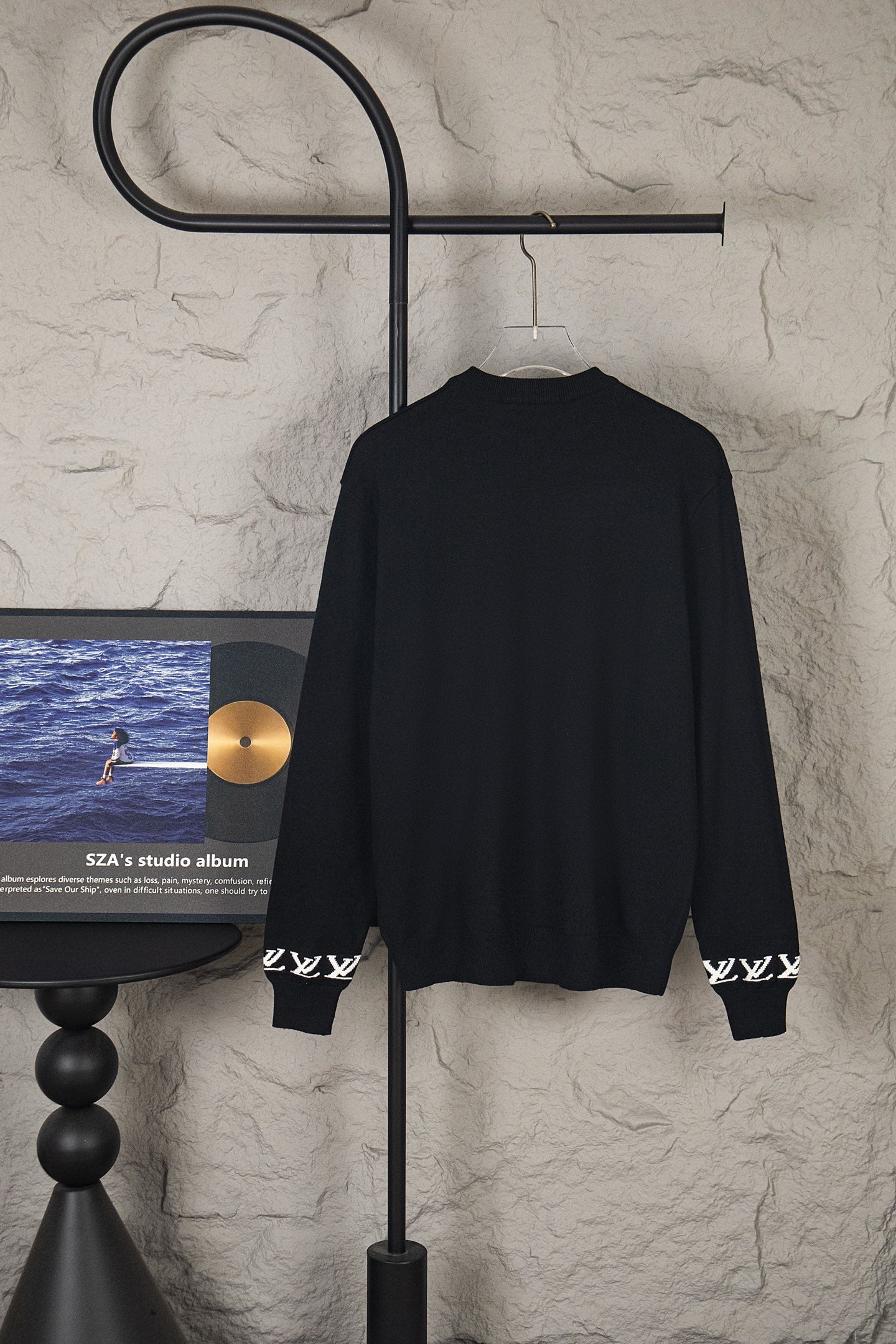 Black long-sleeve knit sweater back view on hanger