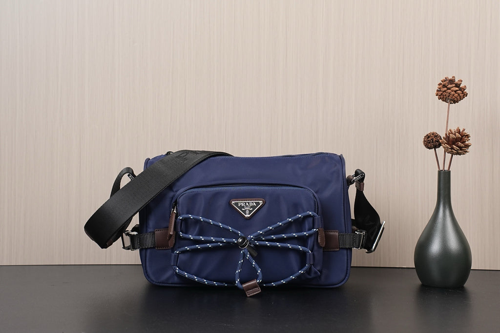 Dark blue Prada nylon crossbody bag with adjustable shoulder strap and front logo patch
