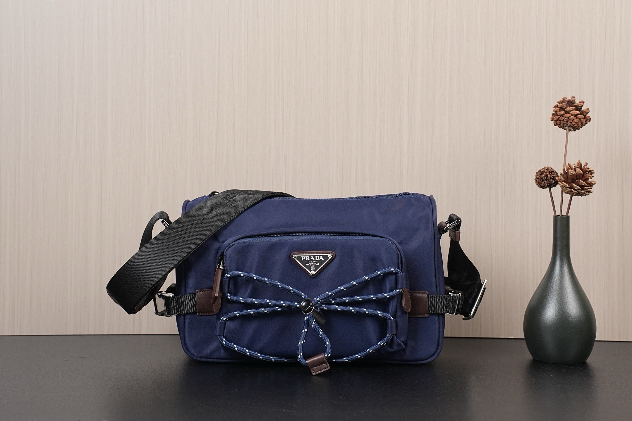 Dark blue Prada nylon crossbody bag with adjustable shoulder strap and front logo patch