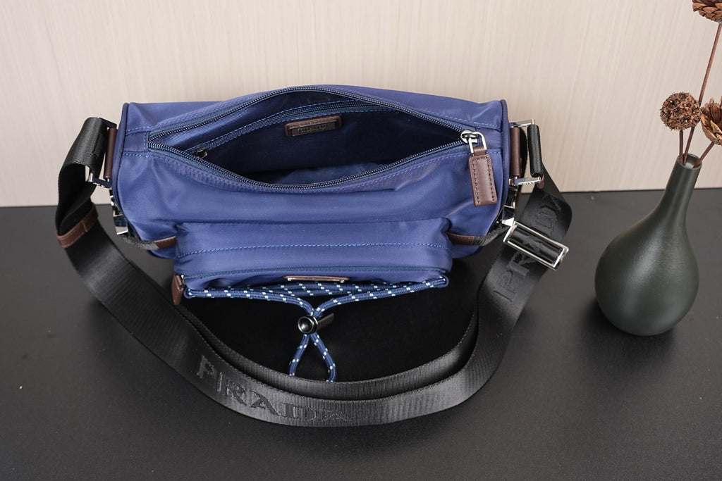 Open dark blue Prada crossbody bag showing interior lining and D-ring hardware