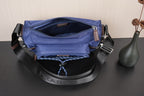 Open dark blue Prada crossbody bag showing interior lining and D-ring hardware