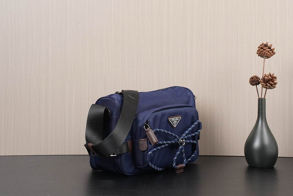 Dark blue Prada crossbody bag, side view showing front pocket and shoulder strap