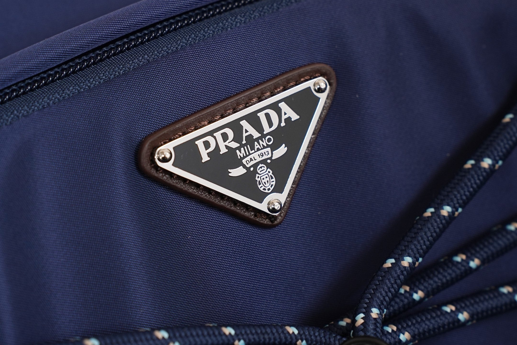 Prada Milano logo patch on blue nylon with metal studs and braided trim