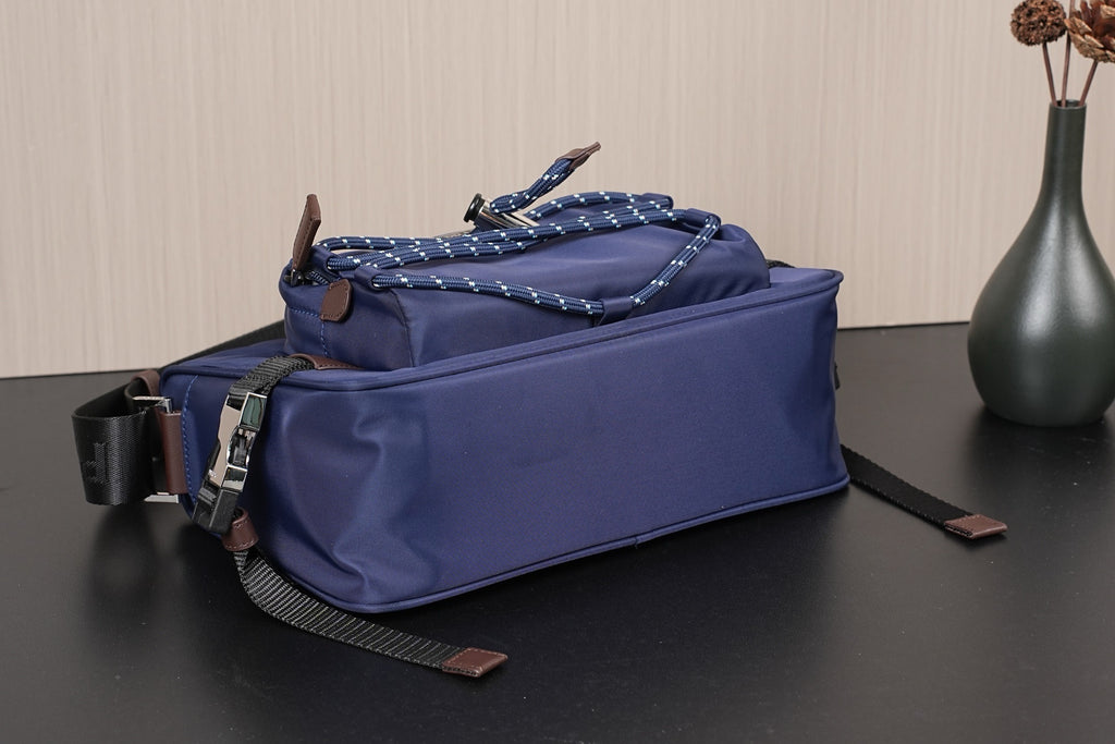 Dark blue Prada crossbody bag, front corner view with braided trim and zipper pull
