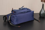 Dark blue Prada crossbody bag, front corner view with braided trim and zipper pull