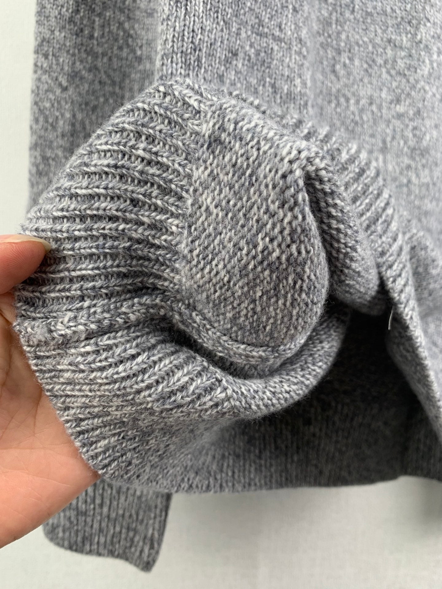 Grey knit sweater sleeve cuff and folded detail