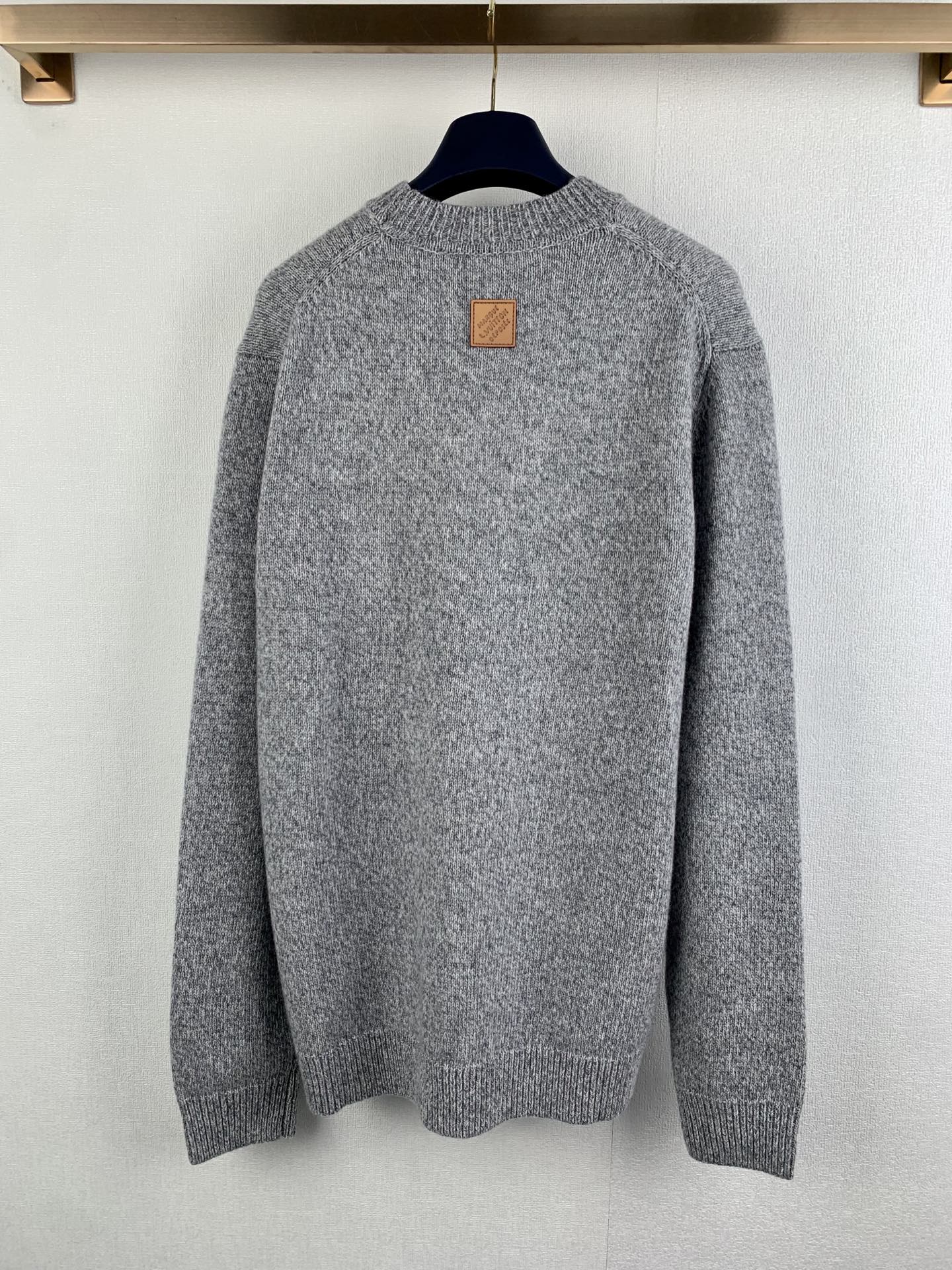 Grey long-sleeve knit sweater back view with small leather-style patch
