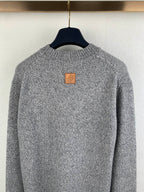 Grey knit sweater back neckline with small leather-style patch