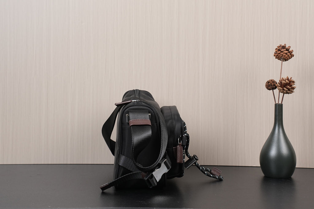 Black Prada crossbody bag with top handle, chain strap, and buckles