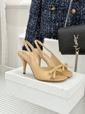 Beige open-toe heeled sandals with crisscross straps and bow at ankle