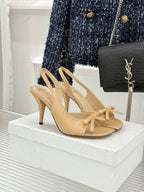 Beige open-toe heeled sandals with crisscross straps and bow at ankle
