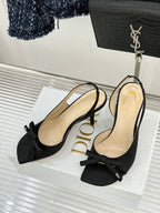 Black open-toe heeled sandal with bow ankle strap and tan insole