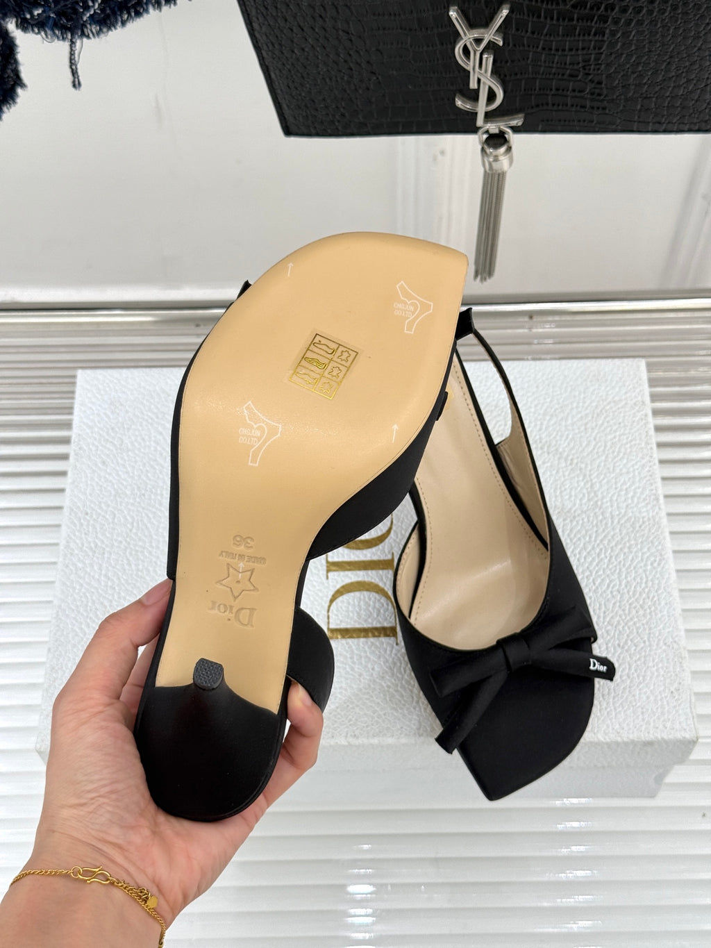 Black heeled sandal with bow at toe and beige outsole underside