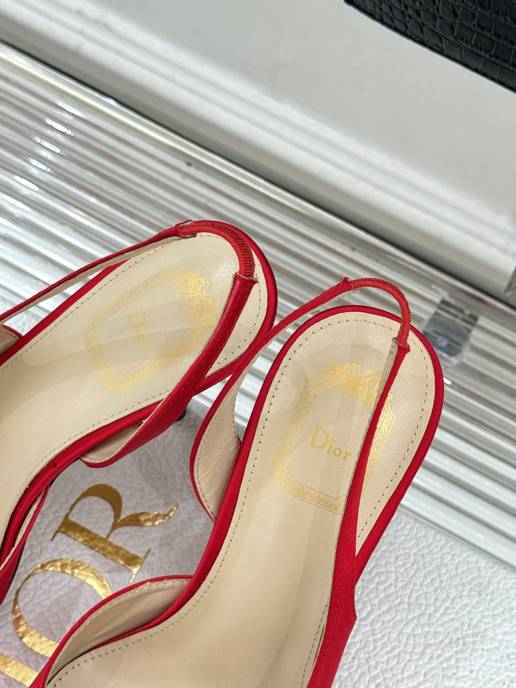 Red stiletto slingback pumps with bow ties, beige interior and heel view