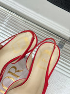 Red stiletto slingback pumps with bow ties, beige interior and heel view