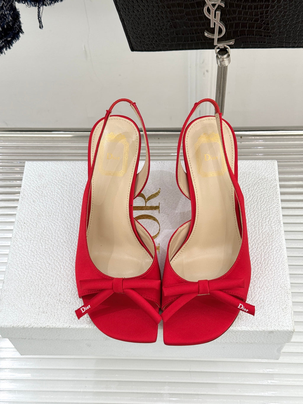 Red stiletto slingback pumps with bow ties and beige interior, top view