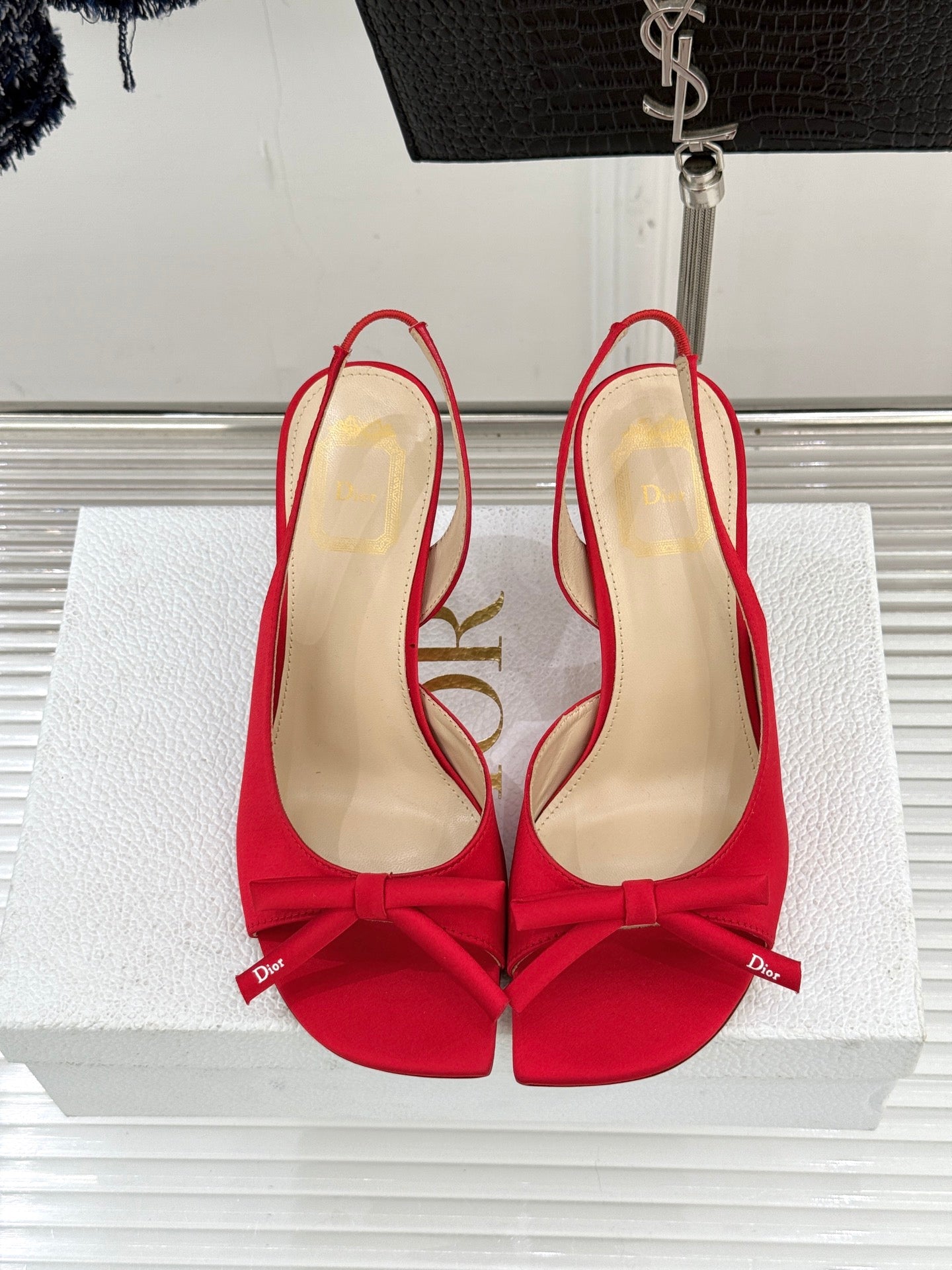 Red stiletto slingback pumps with bow ties and beige interior, top view
