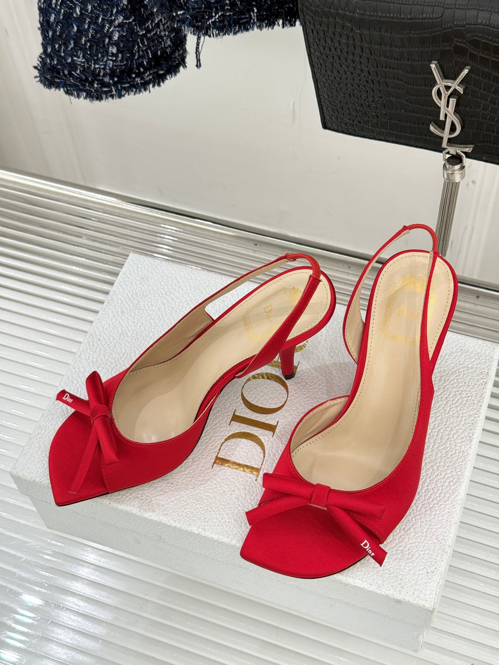 Pair of red stiletto slingback pumps with bow detail and beige lining