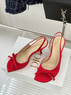 Pair of red stiletto slingback pumps with bow detail and beige lining