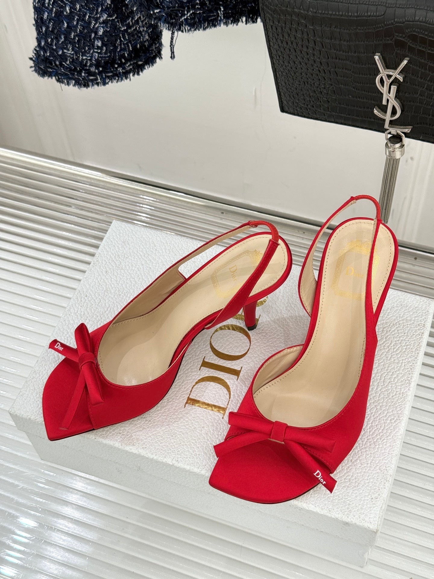 Pair of red stiletto slingback pumps with bow detail and beige lining