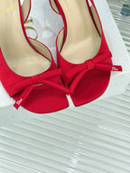 Close-up of red stiletto slingback pumps with bow ties and beige lining
