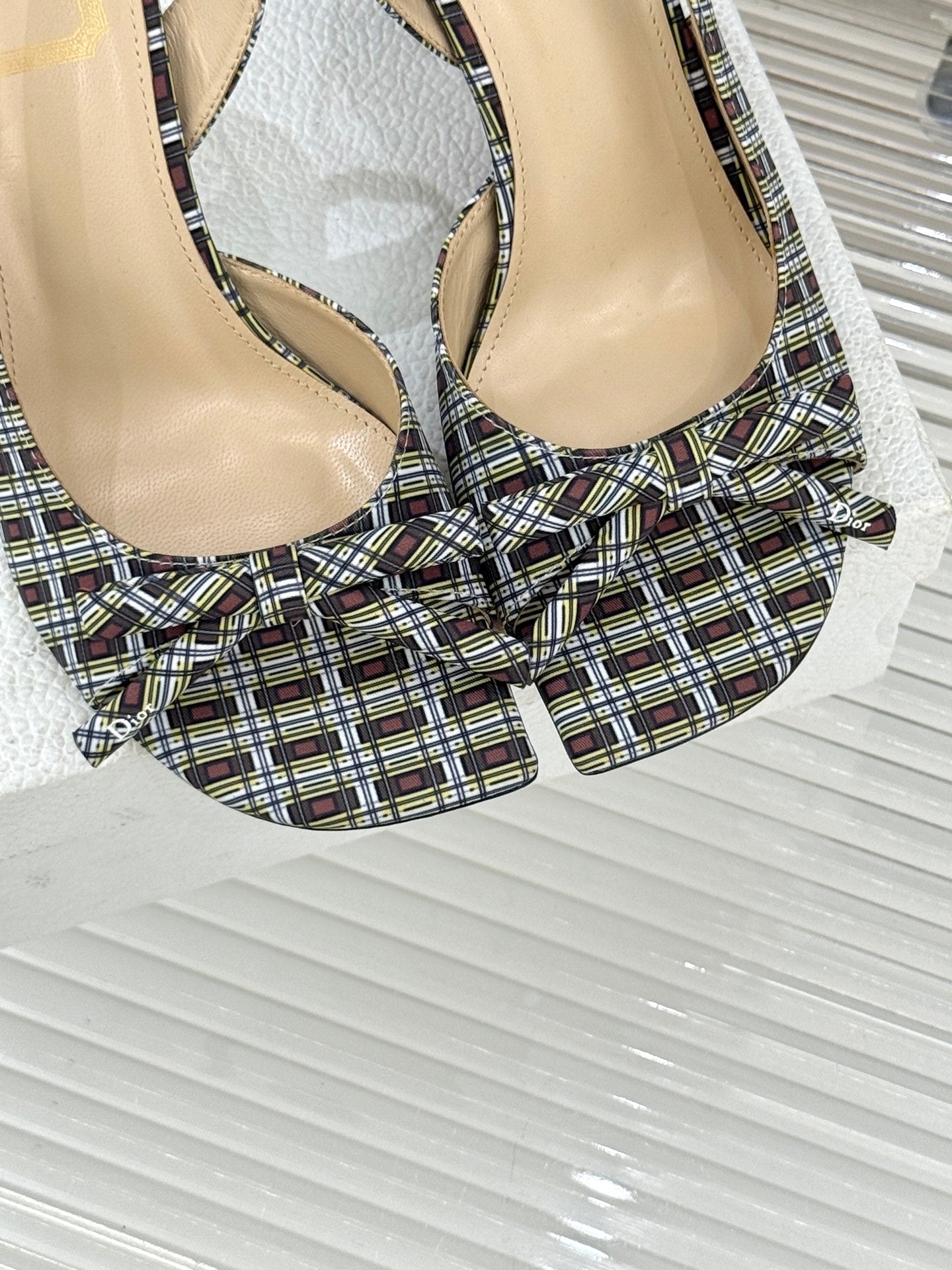 Close-up of women’s plaid slingback heeled sandals with bow and stiletto heel
