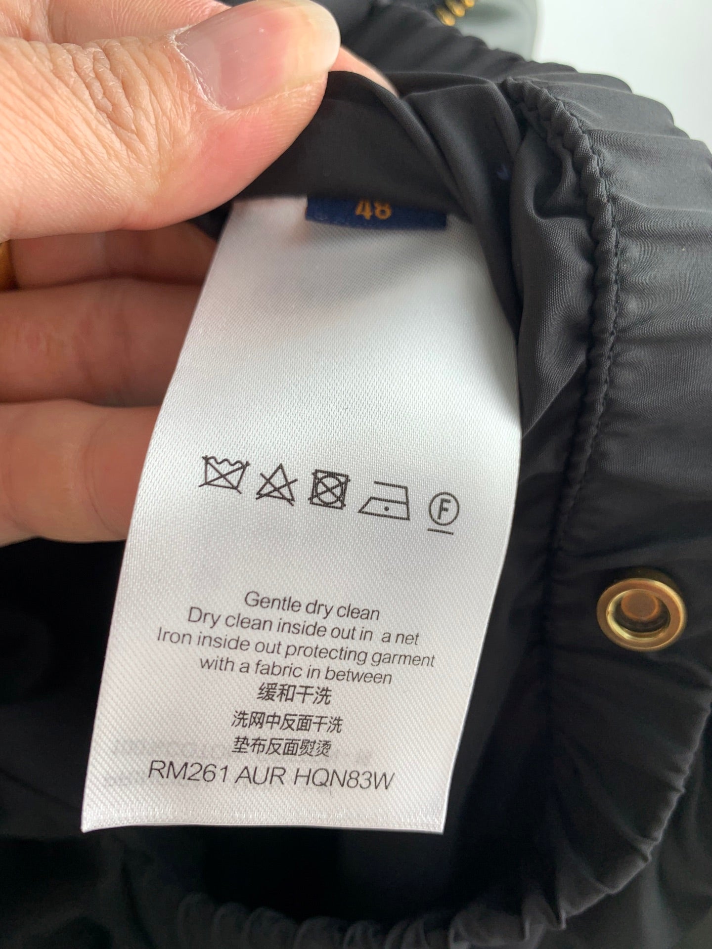 Clothing care label inside black jacket collar