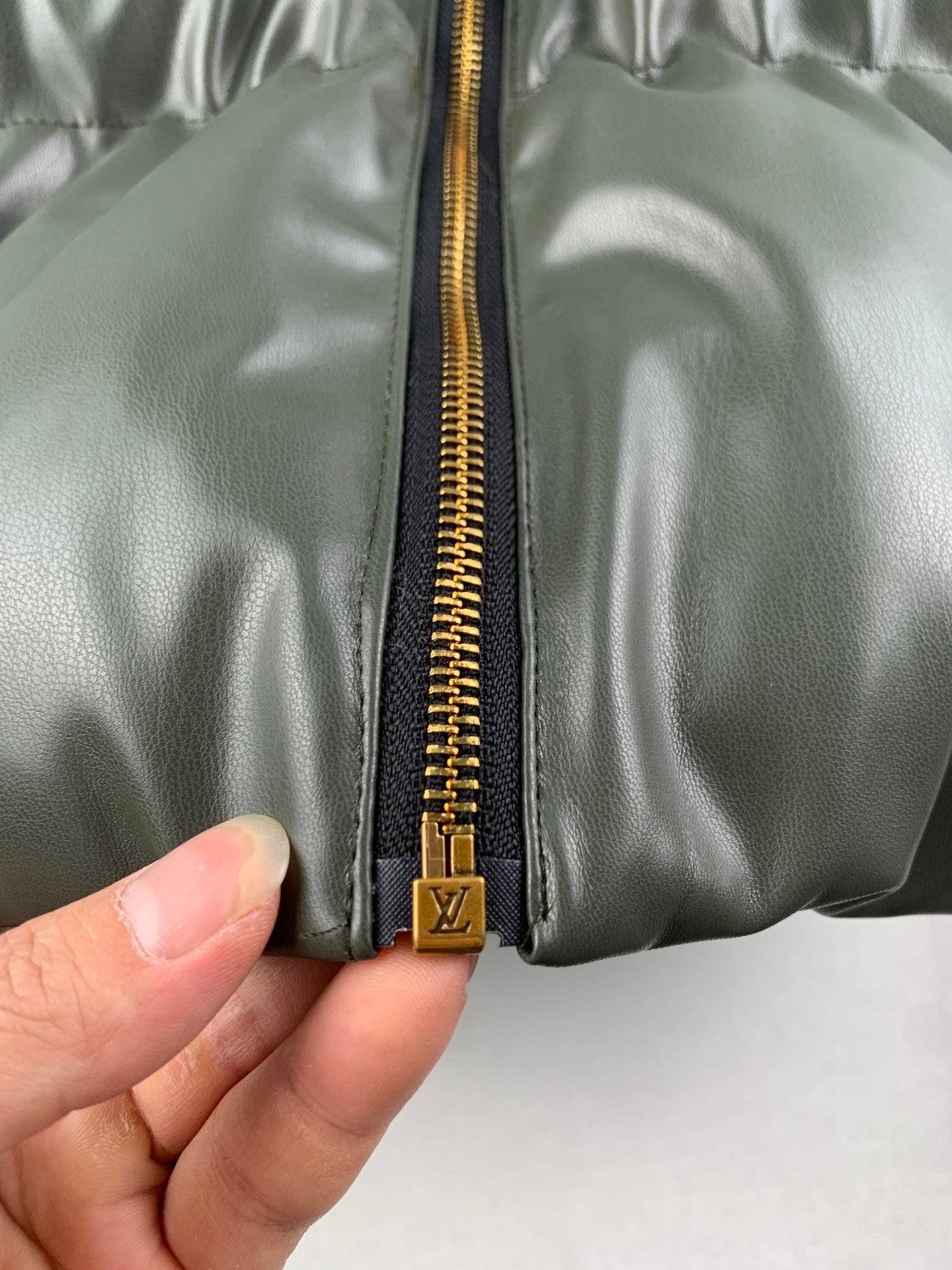 Louis Vuitton front zipper with gold LV pull on olive puffer