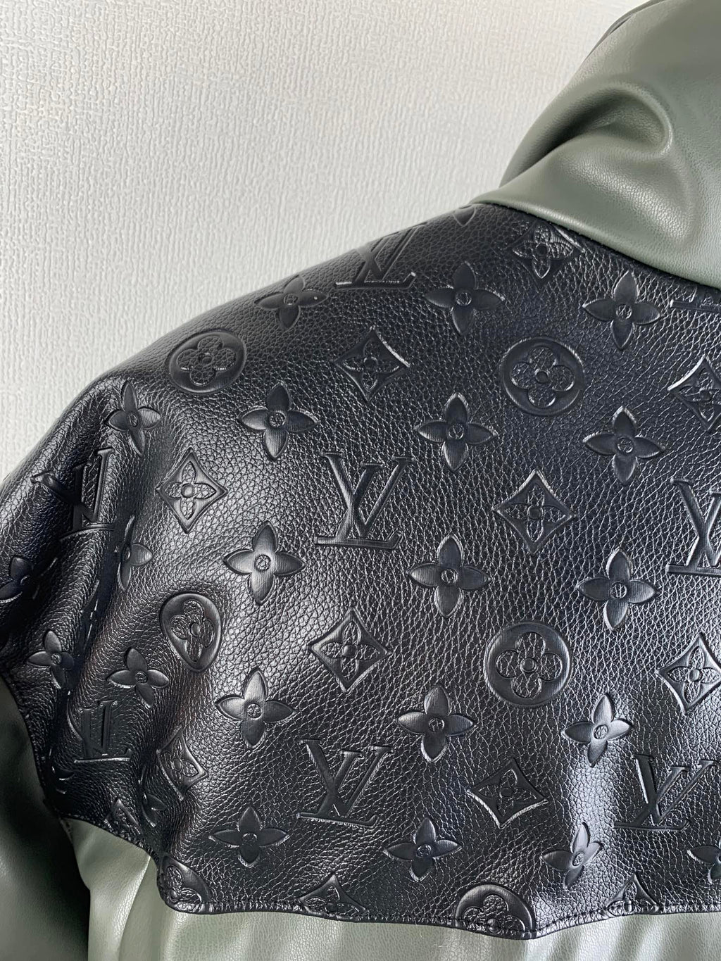 Hooded jacket hood and shoulder with dark monogram emboss texture