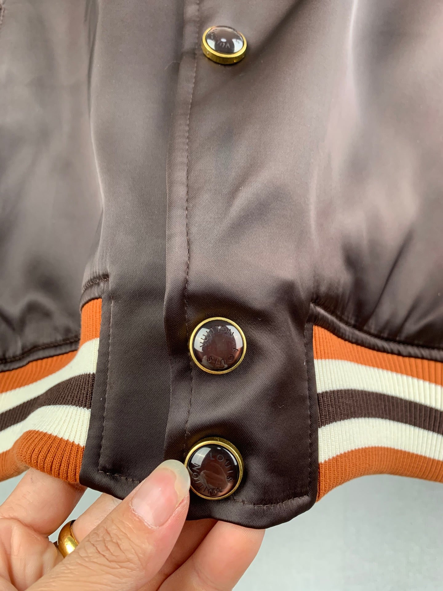 Louis Vuitton bomber jacket sleeve cuff, striped ribbed hem and gold-tone snap buttons