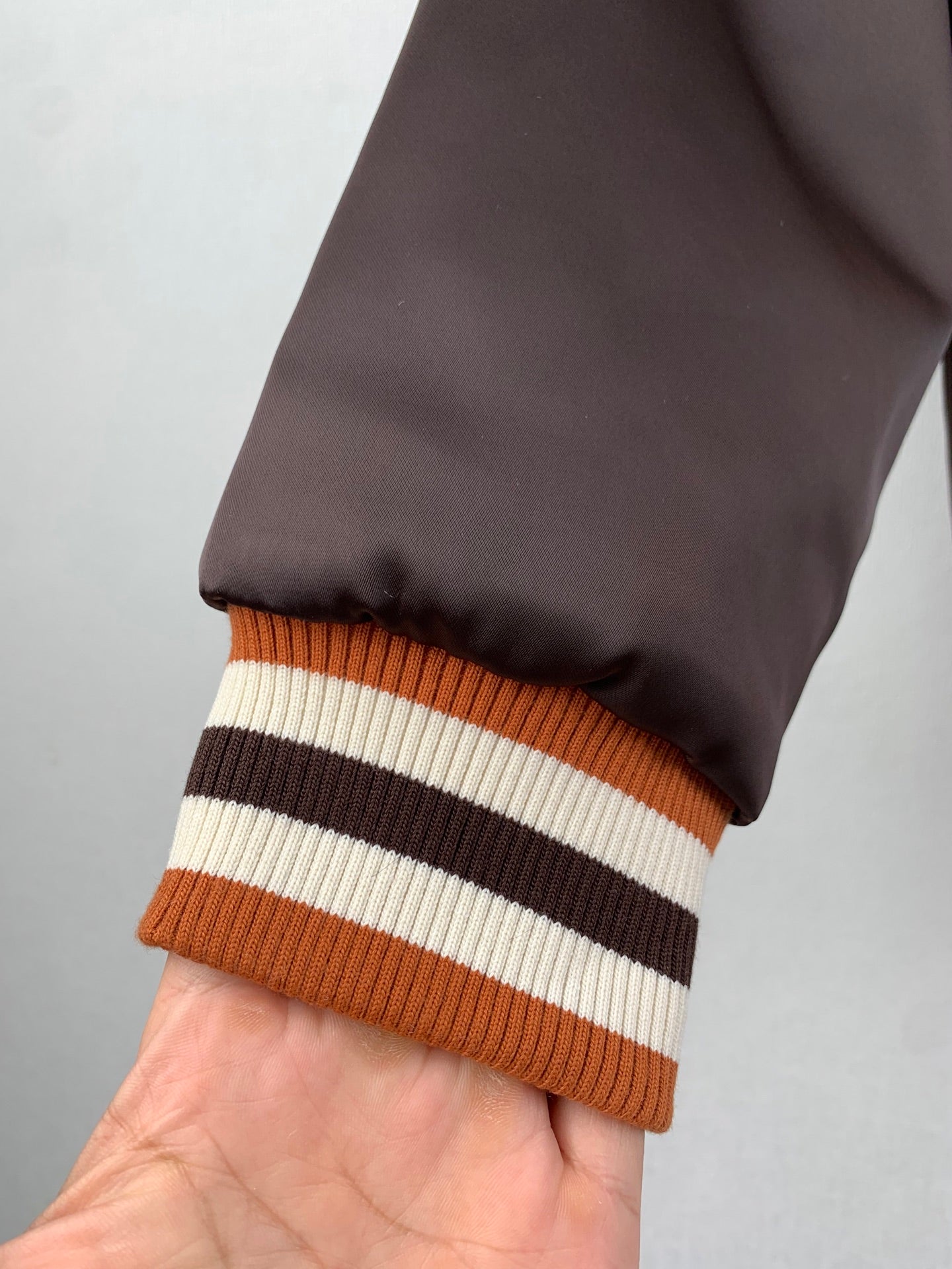 Louis Vuitton bomber jacket sleeve, dark satin with orange and striped ribbed hem
