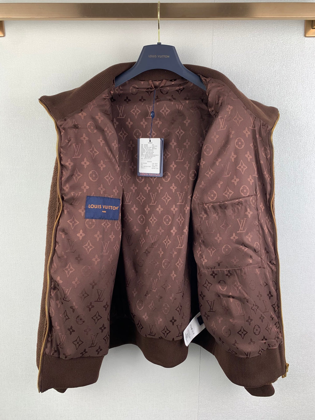Brown Louis Vuitton monogram puffer vest on hanger with blue logo tag
