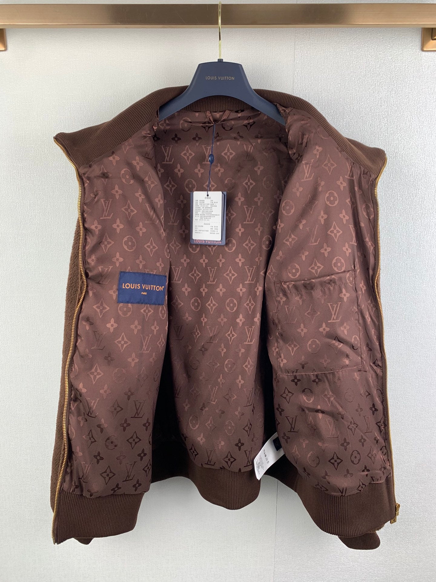 Brown Louis Vuitton monogram puffer vest on hanger with blue logo tag