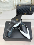 Chanel black-and-white pointed slingback pumps with visible gold detailing on heels