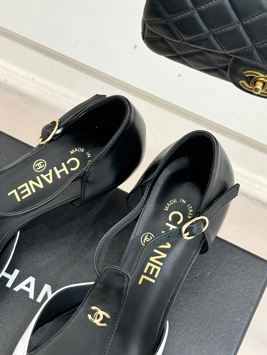 Chanel slingback pumps close-up showing gold hardware and "CHANEL" branding