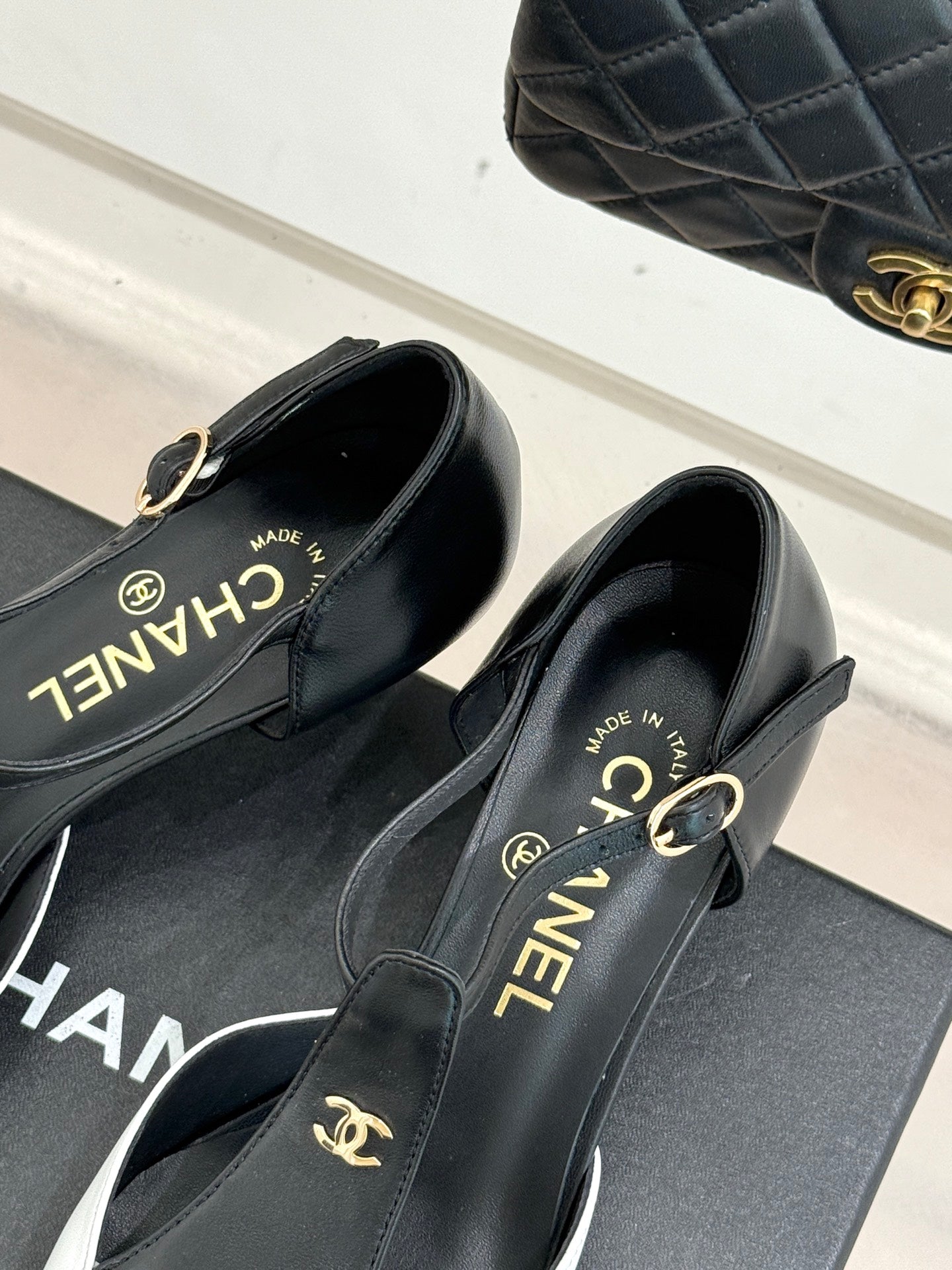 Chanel slingback pumps close-up showing gold hardware and "CHANEL" branding