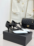 Chanel two-tone pointed-toe slingback pumps, black and white, on a black box