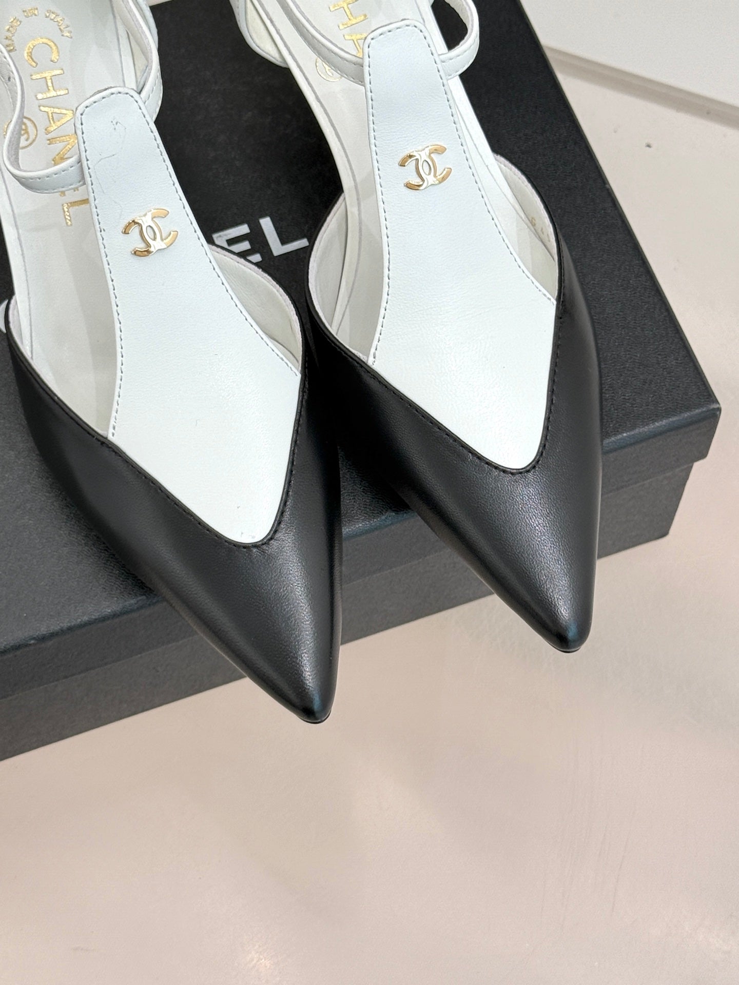 Chanel ladies slingback heels, white pointed-toe design with gold CC logo detail