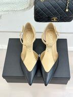 Cream beige pointed-toe slingback heels with ankle straps, side-by-side on boxes.